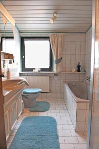 uma casa de banho com uma banheira, um WC e um lavatório. em Pension Biewer em Ockfen