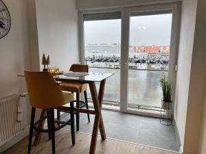una sala da pranzo con tavolo, sedie e finestra di Wolf Apartment Zagreb a Zagabria