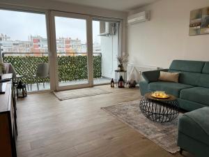 sala de estar con sofá verde y ventana grande en Wolf Apartment Zagreb, en Zagreb