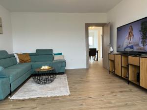 sala de estar con sofá azul y TV de pantalla plana en Wolf Apartment Zagreb, en Zagreb
