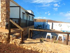 uma casa com duas cadeiras brancas em frente em Casa Elsa em Puerto del Rosario