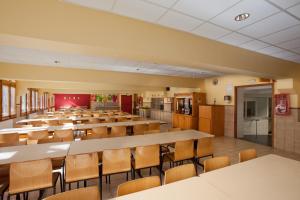 una gran aula con mesas y sillas en una cafetería en Alberg La Molina Xanascat, en La Molina