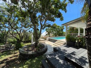 聖吉爾萊班的住宿－Villa tropicale - Meublé de Tourisme 4 Etoiles，后院设有游泳池和树