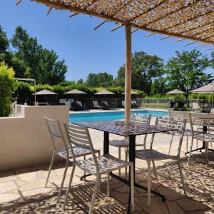 a patio with a table and chairs next to a pool at Camping l'Oso in Porto-Vecchio