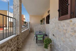 a patio with a table and chairs on a balcony at Appartamento Greco by BarbarHouse in Borgagne
