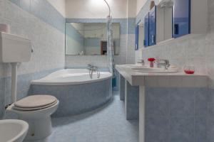 a bathroom with a tub and a toilet and a sink at Appartamento Greco by BarbarHouse in Borgagne