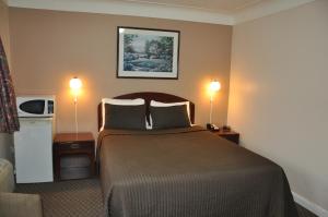 Habitación de hotel con 1 cama grande y 2 lámparas en Royal Inn, en Burlington