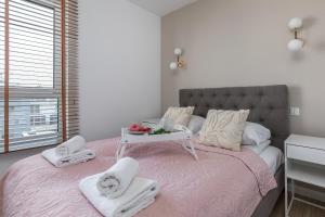ein Schlafzimmer mit einem rosa Bett mit Handtüchern darauf in der Unterkunft Apartamenty Osiedle Bursztynowe III by Renters in Kołobrzeg