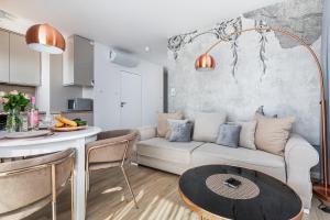 salon z białą kanapą i stołem w obiekcie Apartamenty Osiedle Bursztynowe III by Noclegi Renters w Kołobrzegu
