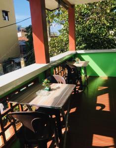 - deux tables et des chaises sur le balcon d'un restaurant dans l'établissement Queen's Room Rental 4, à El Nido