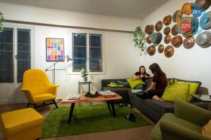 Dos mujeres sentadas en un sofá en una sala de estar en Greenhouse - Kalamata Mediterranean Villas, en Kalamata
