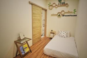 a small room with a bed and a door at 寮寓Laos House三人包棟 in Xiaoliuqiu
