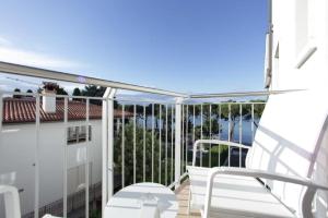 - un balcon avec une chaise blanche dans un bâtiment dans l'établissement Hotel San Marco, à Peschiera del Garda