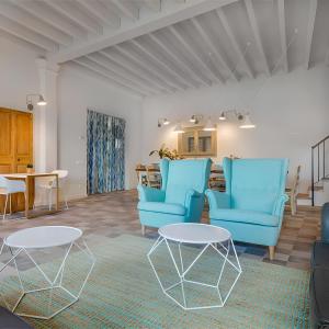 a waiting room with blue chairs and a table at Son Gris in Selva