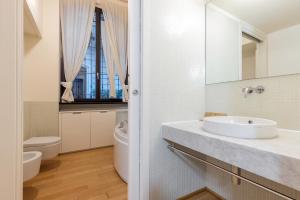 米蘭的住宿－Milan Retreats Navigli，白色的浴室设有水槽和卫生间。