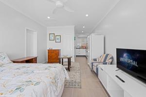 a bedroom with a bed and a flat screen tv at Cardwell Seascape Apartments in Cardwell