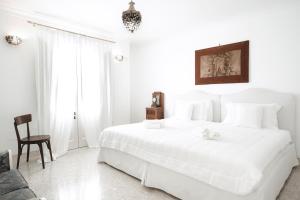 a white bedroom with a large white bed and a chair at Relais Carlo Alberto in Salve