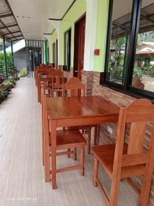 a row of wooden tables and chairs in a restaurant at Rabang Traveller's Inn in San Vicente