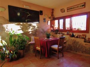 a dining room with a table and chairs and plants at Hostal de la Luz in Cuenca