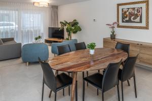 a living room with a wooden table and chairs at Milano Ostend - Casselbergh Residences in Ostend