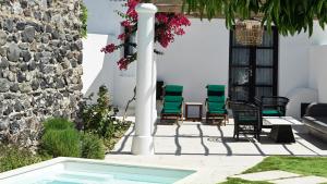 eine Terrasse mit Stühlen und einem Pool in der Unterkunft Katikies Garden Santorini - The Leading Hotels Of The World in Fira