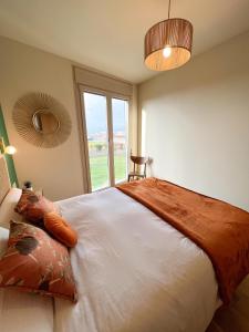 ein Schlafzimmer mit einem großen Bett mit einem großen Fenster in der Unterkunft Apartamento de diseño con Gym y Piscina in Castellón de la Plana