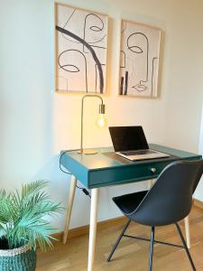 einen Schreibtisch mit einem Laptop und einem Stuhl in der Unterkunft Apartamento de diseño con Gym y Piscina in Castellón de la Plana + 17 Fotos