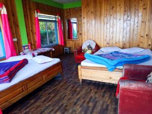 1 dormitorio con 2 camas y 2 sillas en Jhandi Chettri Homestay by StayApart, en Gorubathān