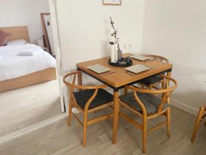An cosy apartment near CPH airport في كوبنهاغن: طاولة خشبية مع كرسيين في غرفة النوم