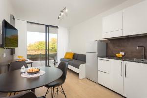 a kitchen and living room with a table and a couch at Residence Del Mar Emotion in Pula