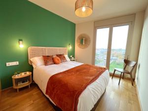 a bedroom with a large bed with a green wall at Apartamento de diseño con Gym y Piscina in Castellón de la Plana