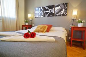 Habitación de hotel con 2 camas con rosas rojas. en Barcelona4Seasons II, en Barcelona