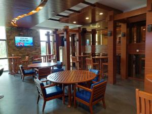 um restaurante com mesas e cadeiras de madeira e uma televisão em Nasau Resort & Villas em Nadi