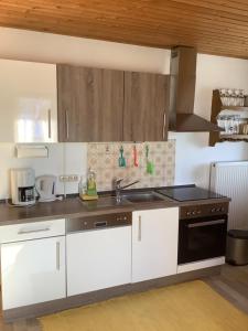 a kitchen with white cabinets and a sink at Haus Liesal in Spiegelau