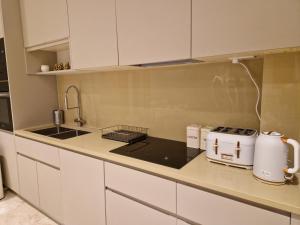 ColindaleにあるSpacious 2 BR with Balcony in Hendonのキッチン(白いキャビネット、カウンタートップ付)
