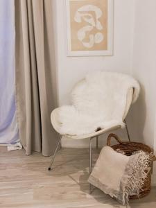 An cosy apartment near CPH airport في كوبنهاغن: كرسي أبيض جالس في غرفة مع سلة