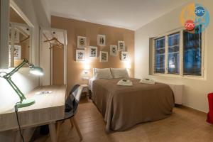 um quarto com uma cama e uma secretária com um candeeiro em Linas Home - Kalamata Mediterranean Villas em Kalamata