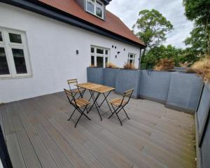 einen Holztisch und Stühle auf einer Terrasse in der Unterkunft Spacious 2 BR with Balcony in Hendon in Colindale