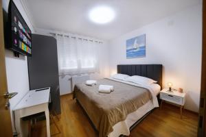 1 dormitorio con 1 cama con 2 toallas en Kalimero apartman A1 en Križevci
