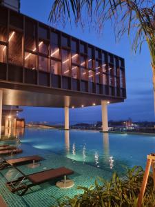 a building with a bridge over a body of water at Rizky D'Bali Homestay @ Bali Residents Melaka in Melaka