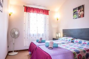 a bedroom with a large bed with pink sheets and a window at Elegant Villa in Ciutadella de Menorca with Private Pool in Sa Caleta