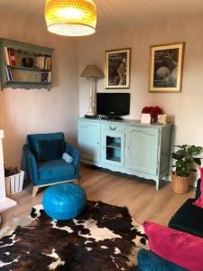 un salon avec une chaise bleue et une télévision dans l'établissement Country house - 5 mns from Fontainebleau, 