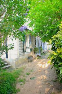 une maison blanche avec des arbres devant elle dans l'établissement Country house - 5 mns from Fontainebleau, 