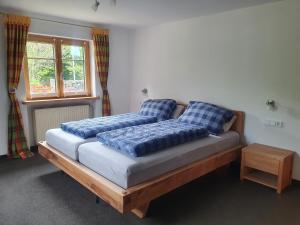 a bed with blue pillows on it in a room at FeWo Stegenbach Oberstaufen/Steibis in Oberstaufen