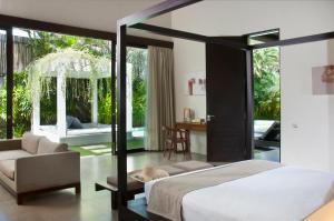 a bedroom with a bed and a living room at Villa Alice in Seminyak