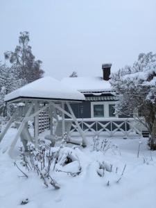 a snow covered gazebo in front of a house at Aurora Center 3 in Rovaniemi