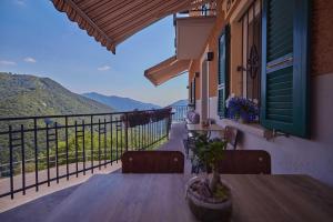 una mesa en un balcón con vistas a las montañas en Osteria Manciana con Alloggio MONTE GENEROSO en Scudellate