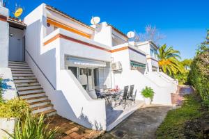a white house with stairs and a table and chairs at Ideal Property Mallorca - El Sol in Alcudia