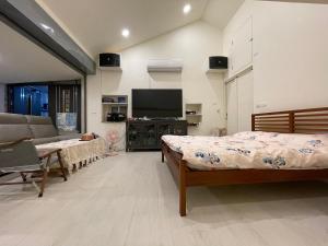 a bedroom with two beds and a flat screen tv at Star & Moon GUEST HOUSE in Hengchun