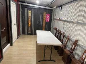 a table in a room with chairs and a door at Star & Moon GUEST HOUSE in Hengchun